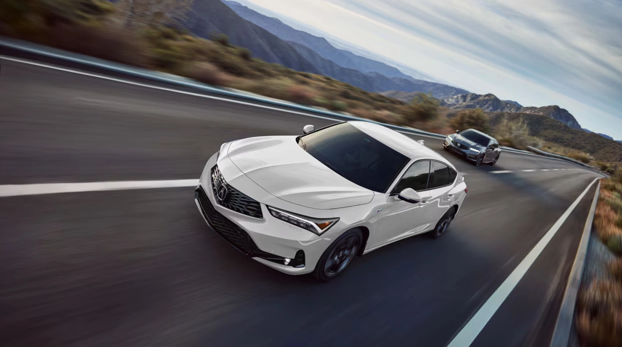 Two 2025 Acura vehicles driving on a scenic mountain road – luxury, performance, and control from Acura Montreal Centre.